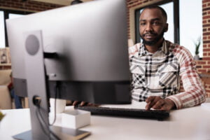 man sitting at a refurbished computer